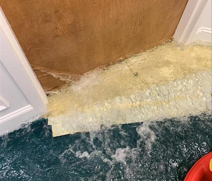 water rushing underneath a wood door