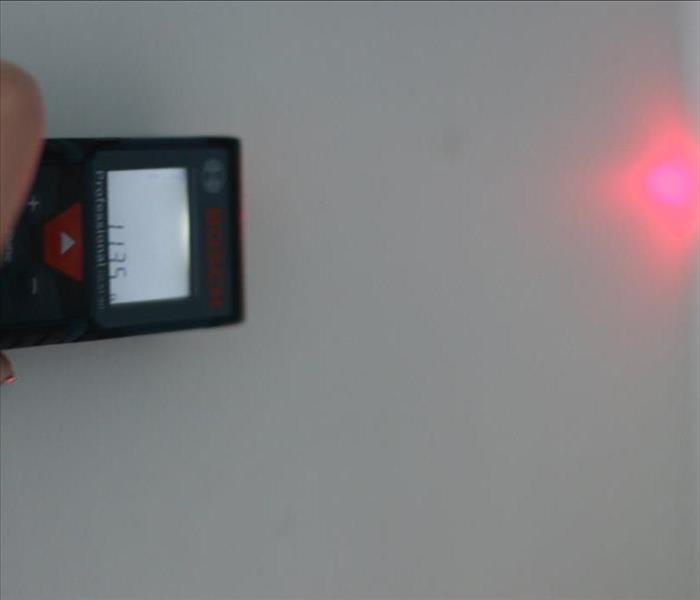 Laser measurement tool shows measurement of wall
