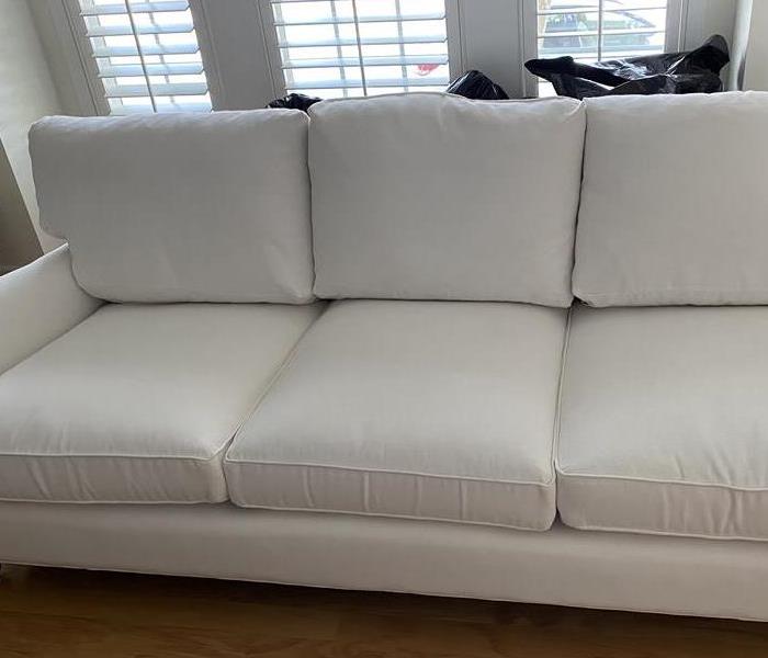 white couch in front of windows on hardwood floors