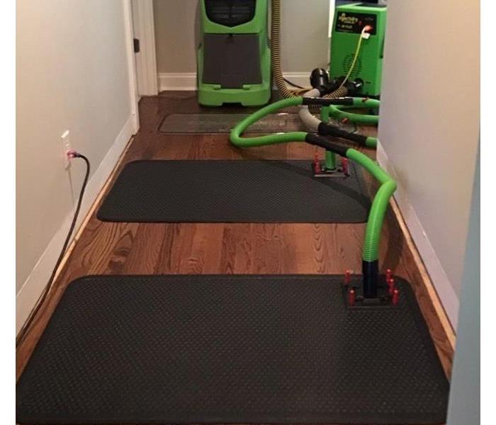 SERVPRO dry mat system being used in a hallway with hardwood floors.