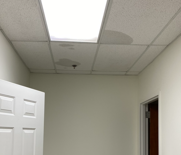 room with wet ceiling tiles and two doors. 