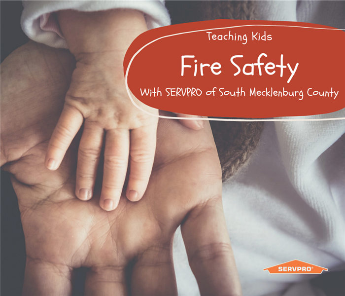 “Teaching kids fire safety” with a picture of child’s hand in adults hand and SERVPRO logo